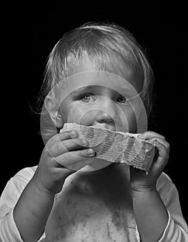 Hungry child eating bread