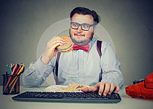 Hungry chunky man eating burger at workplace