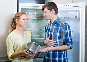 Hungry couple near empty fridge