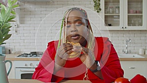 Hungry fat black woman enjoying eating fast food