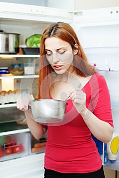 Hungry girl eating from pan