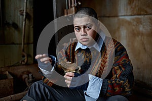 Hungry homeless castoff young woman eating canned food