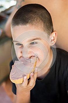 Hungry kid eating bread