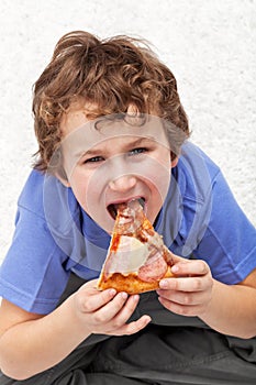 Hungry kid eating pizza