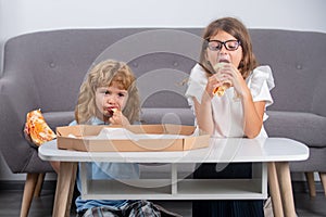 Hungry kids eating pizza. Funny cute children girl and boy eating tasty pizza.