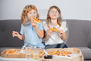 Hungry kids eating pizza. Little girl and boy eat pizza.