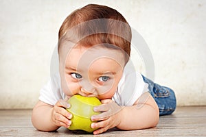 Hungry little baby boy eating apple