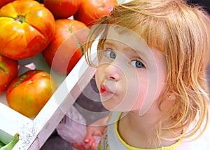 Hungry little girl gesturing in market tomatoes