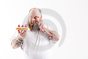 Hungry male looking at cake with desire