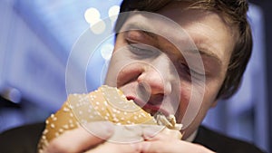 Hungry man with appetite eating hamburger close up