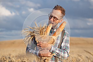 Hungry man bites baguettes in rye field