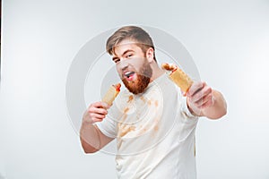 Hungry man in dirty shirt going to eat two hotdogs