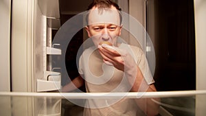 Hungry man finds spoiled cupcake in the refrigerator at night