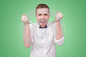 Hungry man holding fork and knife on hand to eat