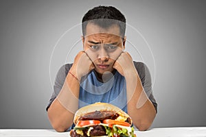 Hungry man looking at big hamburger