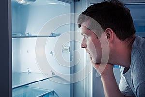 Hungry man looking in refrigerator