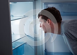 Hungry man looking in refrigerator
