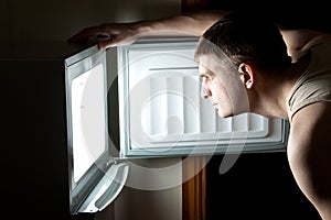 Hungry man opening fridge.