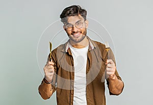 Hungry man waiting for serving dinner meal dishes with restlessness holding cutlery fork knife photo