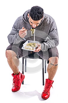 Hungry muscular man gulping down food photo