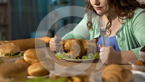 Hungry obese female preparing to dine with fatty roast chicken, stress eating