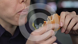 Hungry policewoman eating burger greedily, having lack of time for dinner, duty