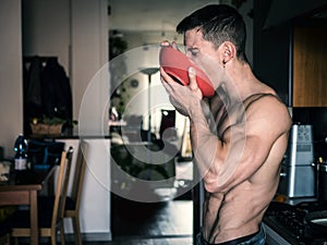 Hungry shirtless guy having breakfast at home photo