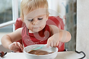 Hungry, sweet and baby eating porridge for health, nutrition or child development at home. Food, cute and girl toddler