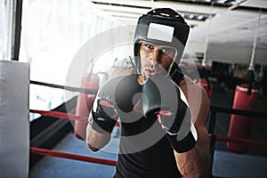 Hungry for that winning title. Portrait of a young man training in a boxing ring.