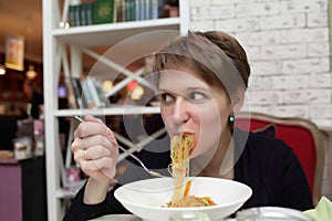 Hungry woman eating noodles