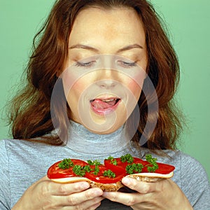 Hungry woman holds sandwich