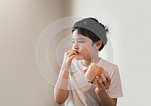 Hungry young boy eating homemade bacon sandwiches with mixed vegetables, Healthy Kid having breakfast at home, Child bitting