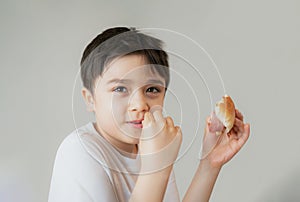 Hungry young boy eating homemade bacon sandwiches with mixed vegetables, Healthy Kid having breakfast at home, Child bitting