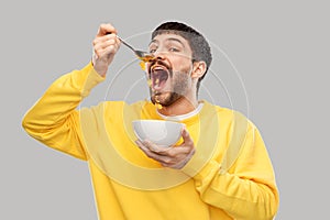 Hungry young man eating cereals