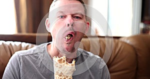 Hungry young man eats delicious shawarma with pleasure