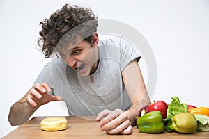 Hungry young man sitting at the table