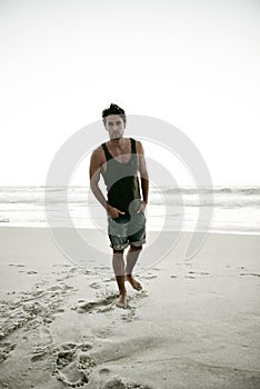 Hunk on a solitary stroll. Full length shot of a handsome young man at the beach.