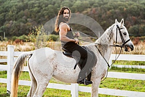Hunky cowboy. Young muscular guy in t-shirt on horseback. Man riding a horse. Hunky cowboy rides horse. Country life photo