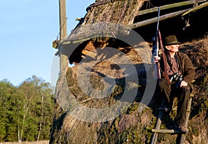 Hunter, game shooting and man on a safari gun at outlook post for animal and wild hunting. Male person, poacher and