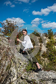 hunter girl shooting bow and arrow in the grassland