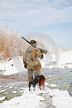 Hunter with his hunting dog during a winter hunt photo