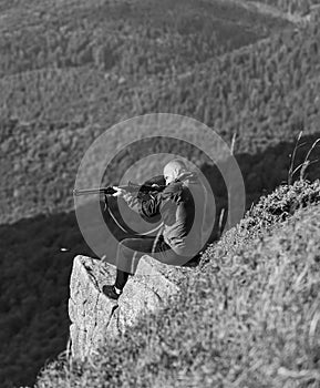 Hunter hold rifle. Hunter spend leisure hunting. Hunting in mountains. Man brutal gamekeeper nature landscape background photo