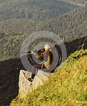Hunter hold rifle. Hunter spend leisure hunting. Hunting in mountains. Man brutal gamekeeper nature landscape background photo