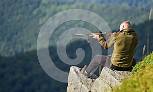 Hunter hold rifle. Hunter spend leisure hunting. Man brutal gamekeeper nature landscape background. Hunting in mountains photo