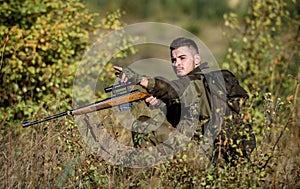 Hunter hold rifle. Man wear camouflage clothes nature background. Hunting permit. Bearded serious hunter spend leisure