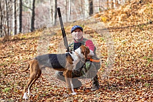 Hunter and hunting dog chasing in the forest