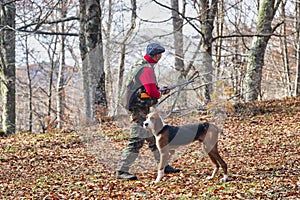 Hunter and hunting dog chasing in the forest