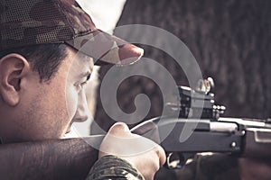 Hunter man aiming and prepared to make a shoot during hunting