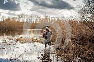 Hunter man creeping in swamp during hunting period