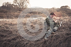 Hunter preparing for hunting in morinig field nearby river